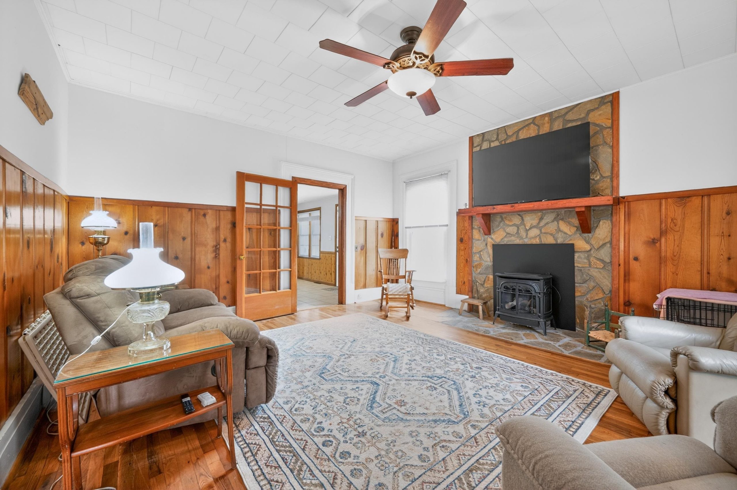 Historic farmhouse living room with stone fireplace.