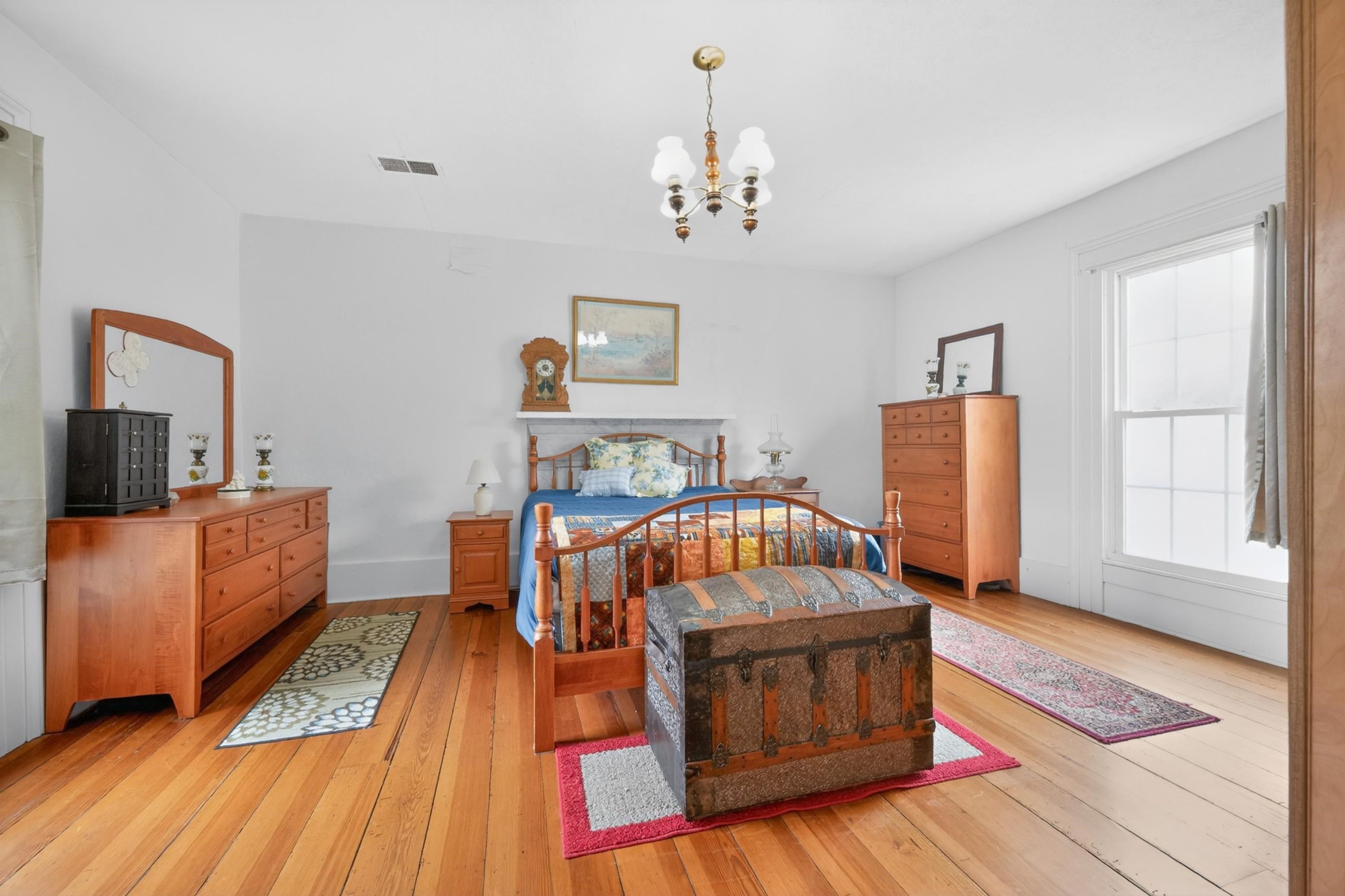 Bedroom with wooden floors and white walls.