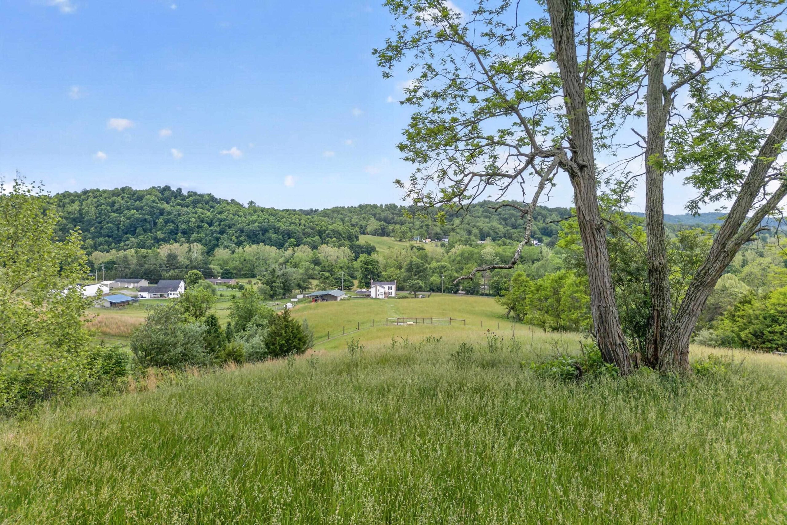 Long range views of a farm from the top of a hill.